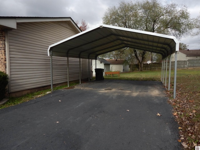 view of vehicle parking featuring a yard and a carport