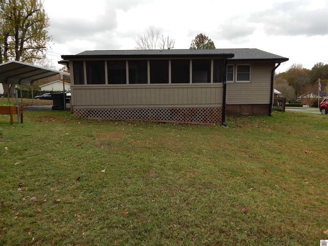 rear view of property with a yard and a carport