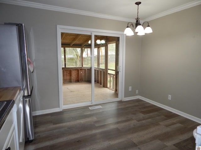 unfurnished dining area with dark hardwood / wood-style flooring, ornamental molding, and an inviting chandelier