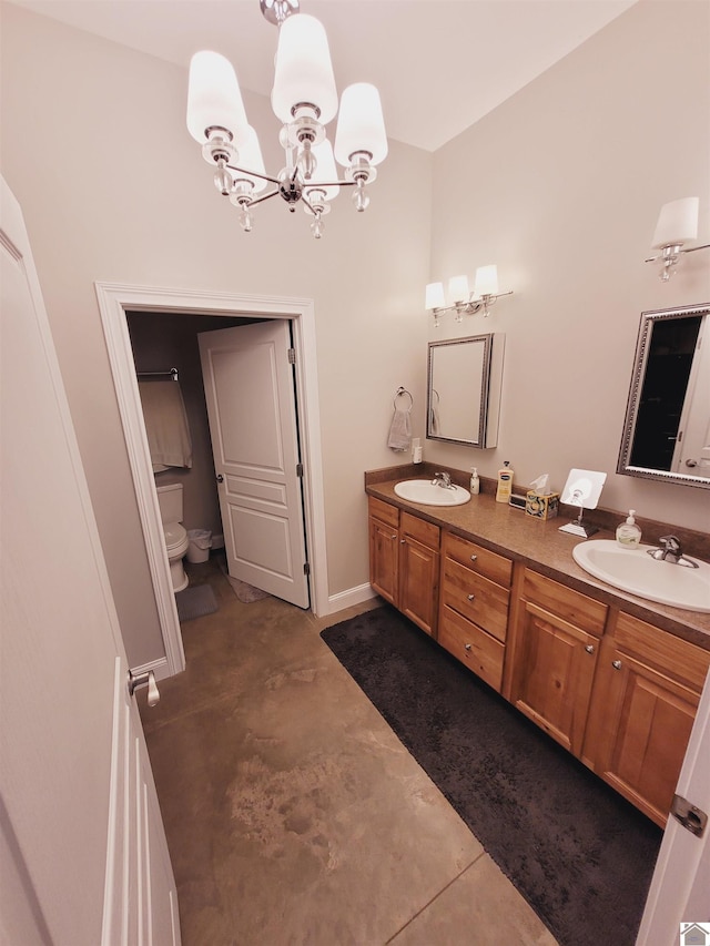 bathroom with concrete flooring, vanity, a chandelier, and toilet