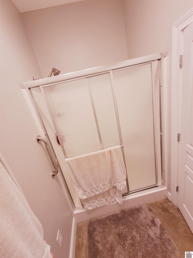 bathroom with concrete floors and a shower with shower door