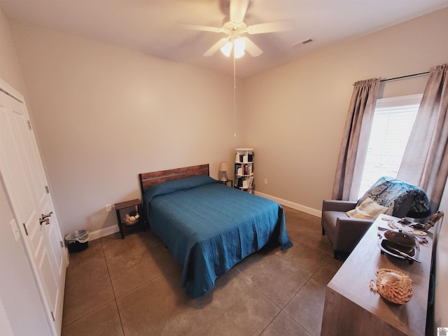 bedroom with ceiling fan and dark tile patterned floors