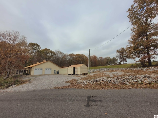 view of front of property featuring a garage and a shed