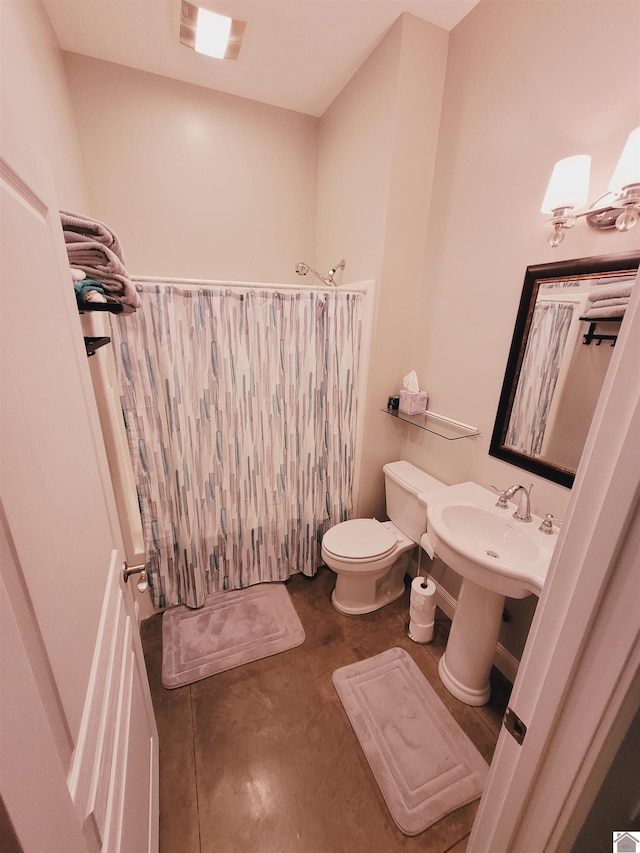 bathroom featuring concrete flooring and toilet