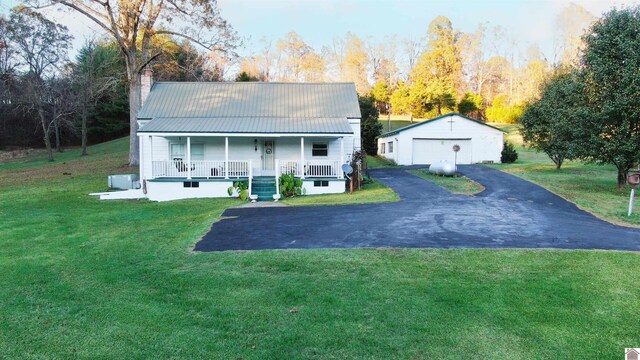 view of front of home with an outbuilding, a porch, a garage, and a front yard