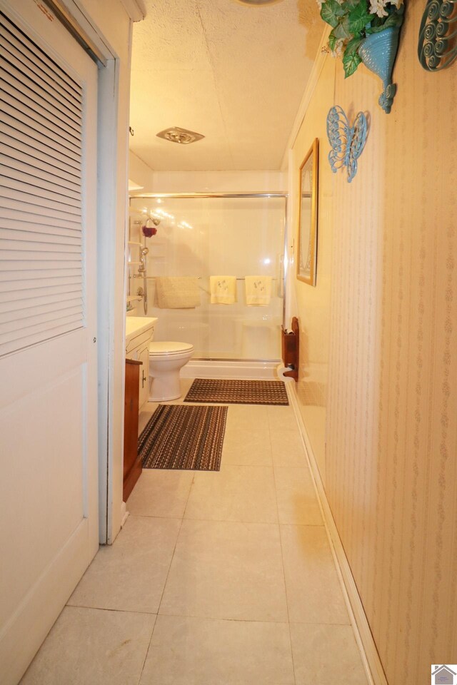 corridor with light tile patterned floors and a textured ceiling