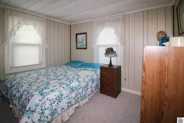 carpeted bedroom featuring wood walls