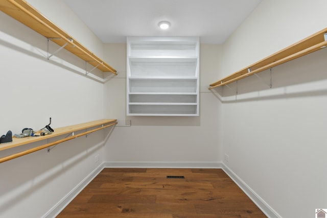 walk in closet with dark hardwood / wood-style floors