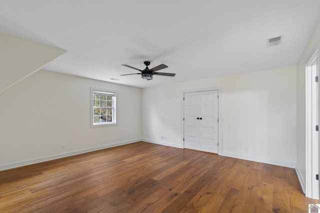 unfurnished bedroom with hardwood / wood-style floors, ceiling fan, and a closet