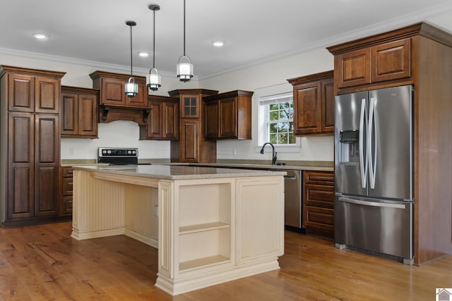 kitchen featuring stainless steel appliances, a kitchen island, crown molding, and light hardwood / wood-style flooring