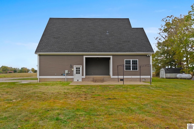 rear view of house with a lawn, a patio, and a shed