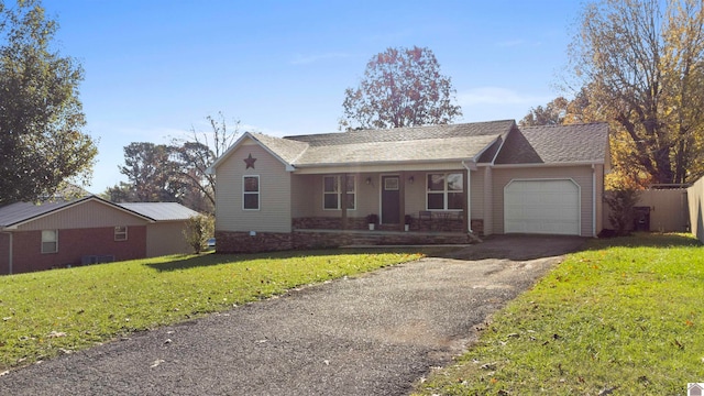 single story home with covered porch, a garage, and a front lawn