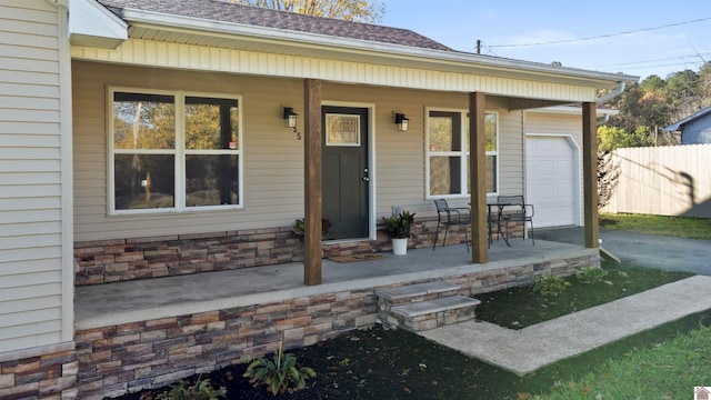 entrance to property with covered porch and a garage