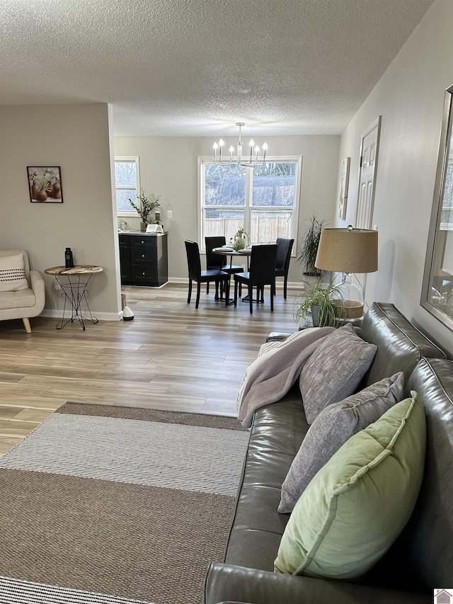 living room with a chandelier, wood-type flooring, and a textured ceiling