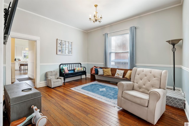 living room featuring hardwood / wood-style flooring, an inviting chandelier, and crown molding