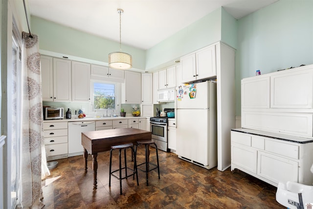 kitchen with white cabinets, white appliances, hanging light fixtures, and sink