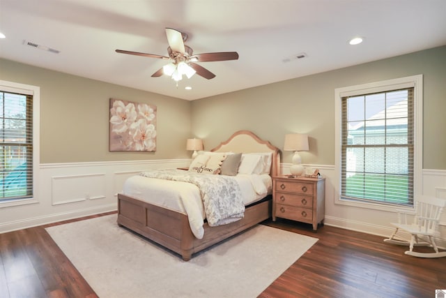 bedroom featuring dark hardwood / wood-style floors, multiple windows, and ceiling fan