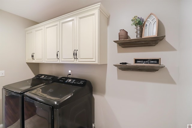 laundry area featuring washing machine and clothes dryer and cabinets