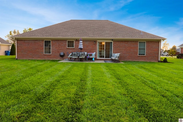 rear view of house with a patio and a lawn