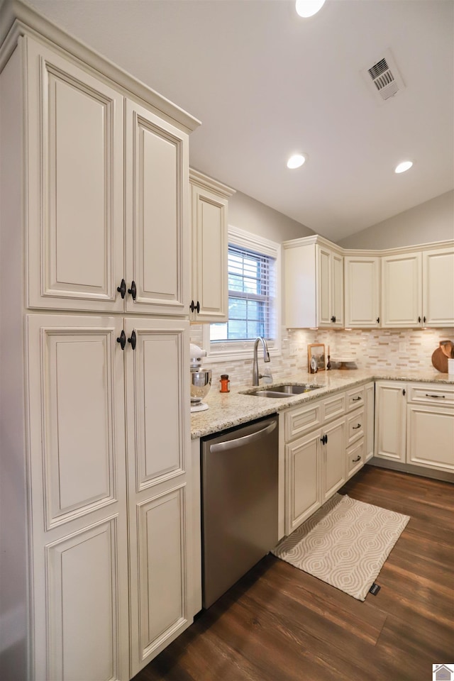 kitchen with sink, vaulted ceiling, stainless steel dishwasher, dark hardwood / wood-style floors, and cream cabinetry