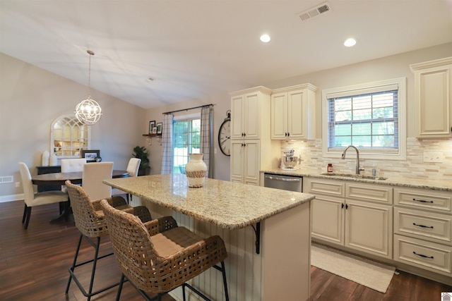 kitchen featuring light stone countertops, sink, a center island, and dark wood-type flooring