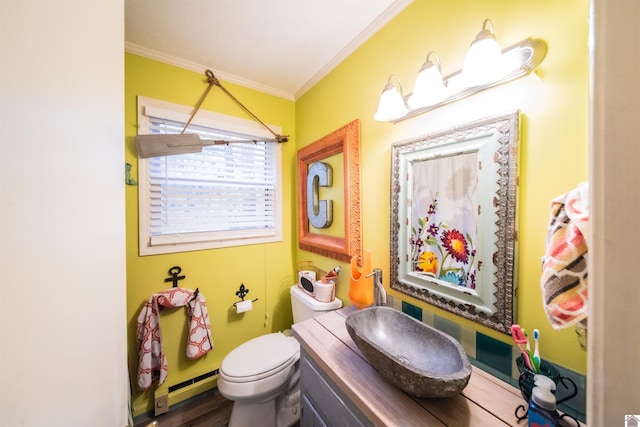 bathroom featuring vanity, a baseboard heating unit, hardwood / wood-style flooring, toilet, and ornamental molding