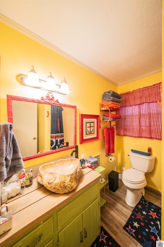 bathroom with toilet, hardwood / wood-style floors, vanity, and ornamental molding