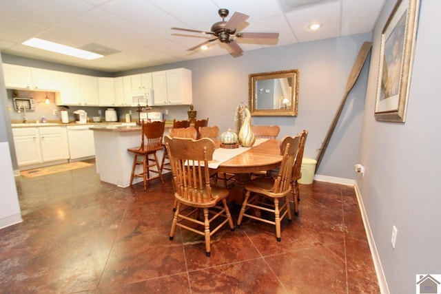 dining room featuring ceiling fan and dark tile patterned floors