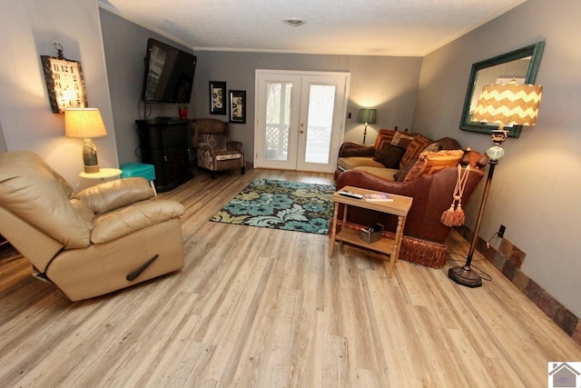 living room featuring light hardwood / wood-style floors, crown molding, and french doors