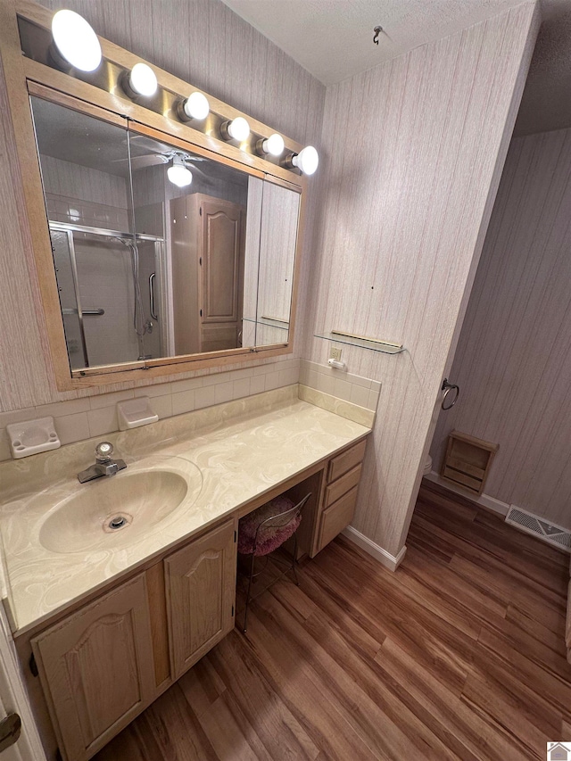 bathroom featuring wood-type flooring, vanity, and walk in shower