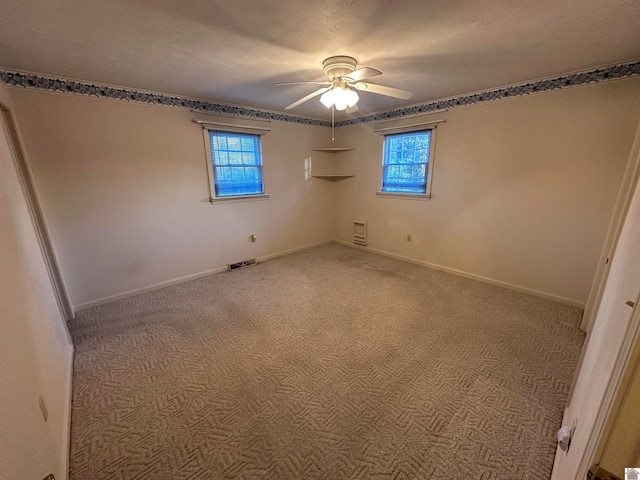 empty room with ceiling fan and carpet floors