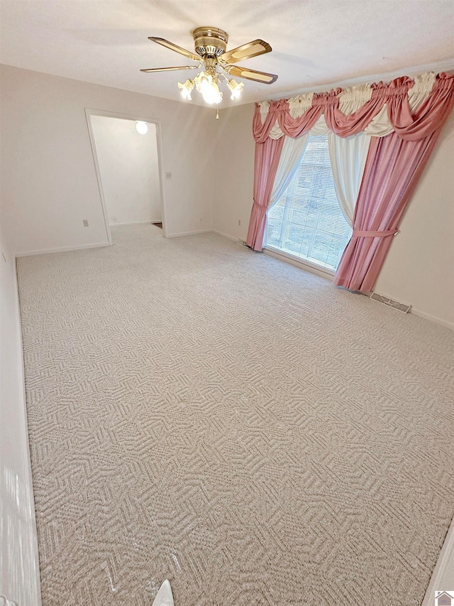 unfurnished room with ceiling fan and carpet