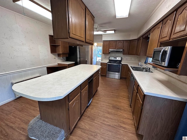 kitchen featuring hardwood / wood-style floors, sink, ceiling fan, a textured ceiling, and stainless steel appliances