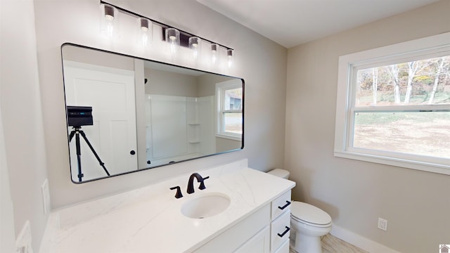 bathroom featuring vanity, toilet, and walk in shower