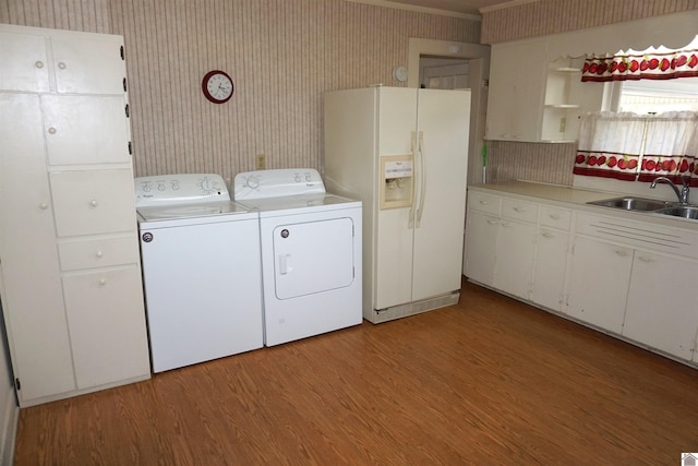 laundry area with light hardwood / wood-style floors, independent washer and dryer, and sink