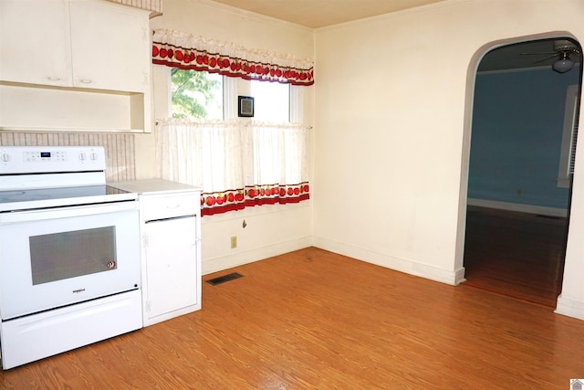 kitchen with white electric range oven, light wood-type flooring, white cabinetry, and ornamental molding