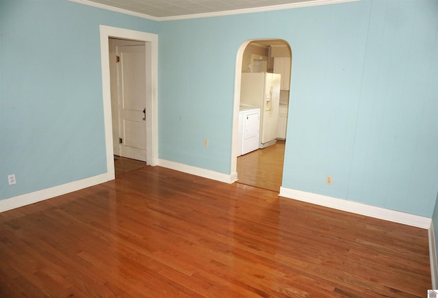 unfurnished room featuring hardwood / wood-style floors, independent washer and dryer, and ornamental molding