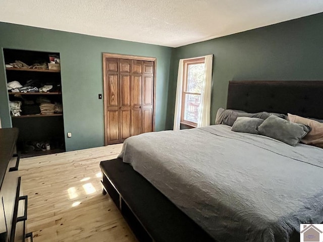 bedroom featuring hardwood / wood-style floors, a textured ceiling, and a closet