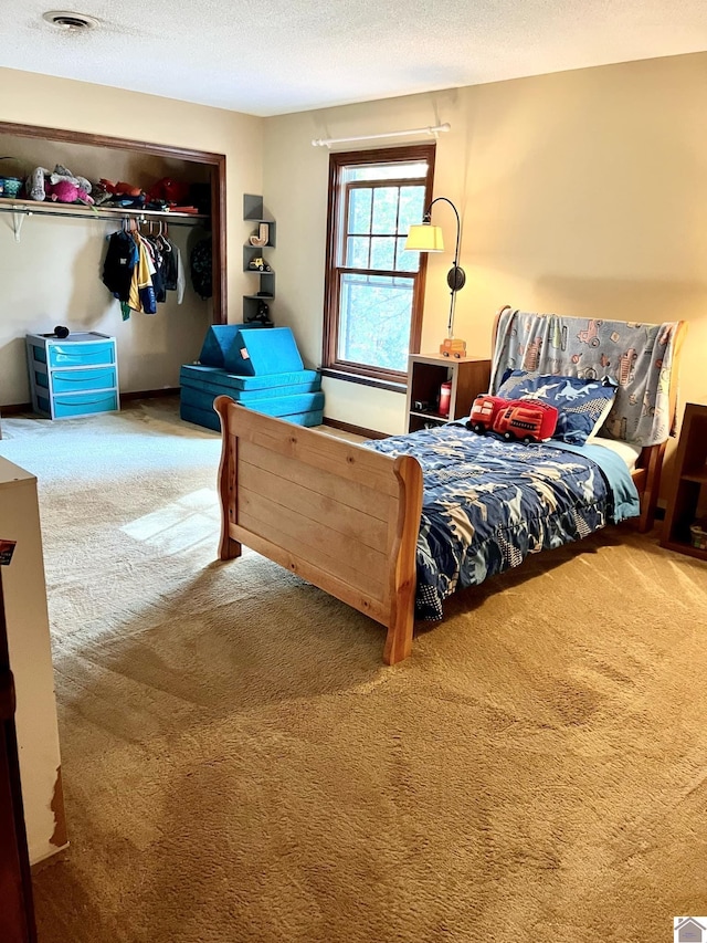 carpeted bedroom featuring a closet and a textured ceiling