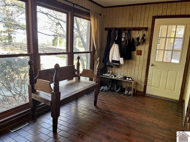 mudroom with wood walls and ornamental molding