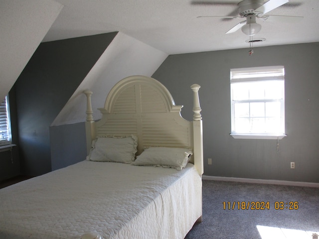 carpeted bedroom featuring a textured ceiling, vaulted ceiling, and ceiling fan