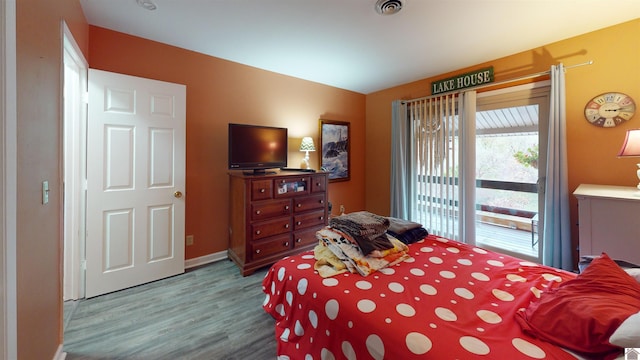 bedroom featuring access to exterior and wood-type flooring