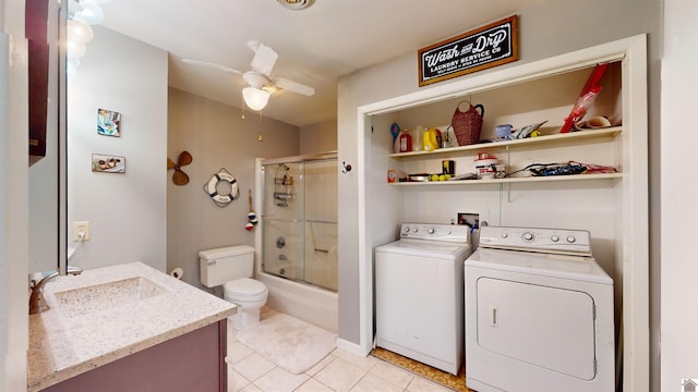 clothes washing area featuring light tile patterned floors, sink, washer and clothes dryer, and ceiling fan