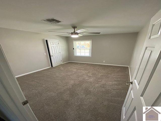 unfurnished bedroom with ceiling fan and dark carpet