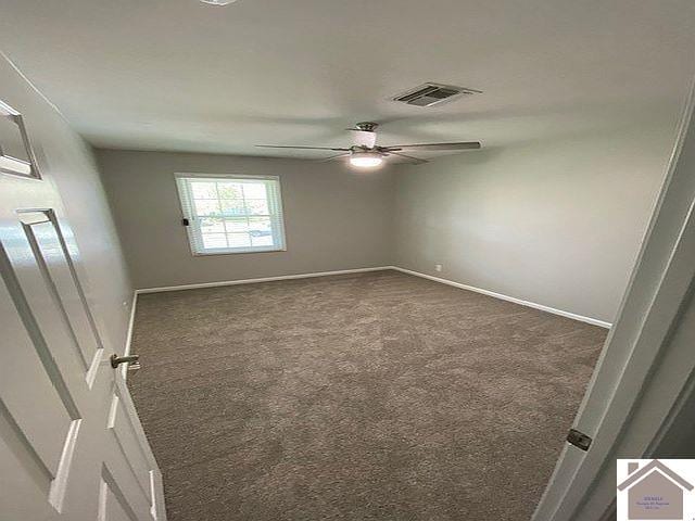 unfurnished room featuring ceiling fan and dark colored carpet