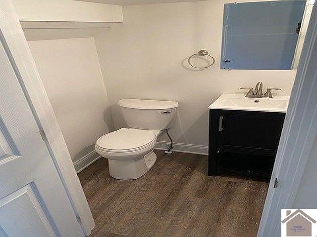 bathroom with vanity, toilet, and wood-type flooring