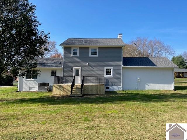 back of property featuring a yard, a deck, and cooling unit