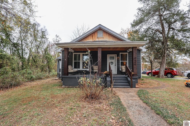 bungalow-style home with a front lawn and covered porch