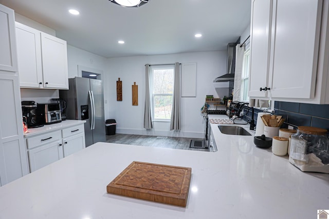 kitchen with white cabinets, appliances with stainless steel finishes, and hardwood / wood-style floors