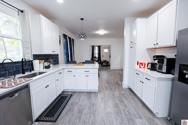 kitchen featuring kitchen peninsula, white cabinetry, pendant lighting, and stainless steel appliances